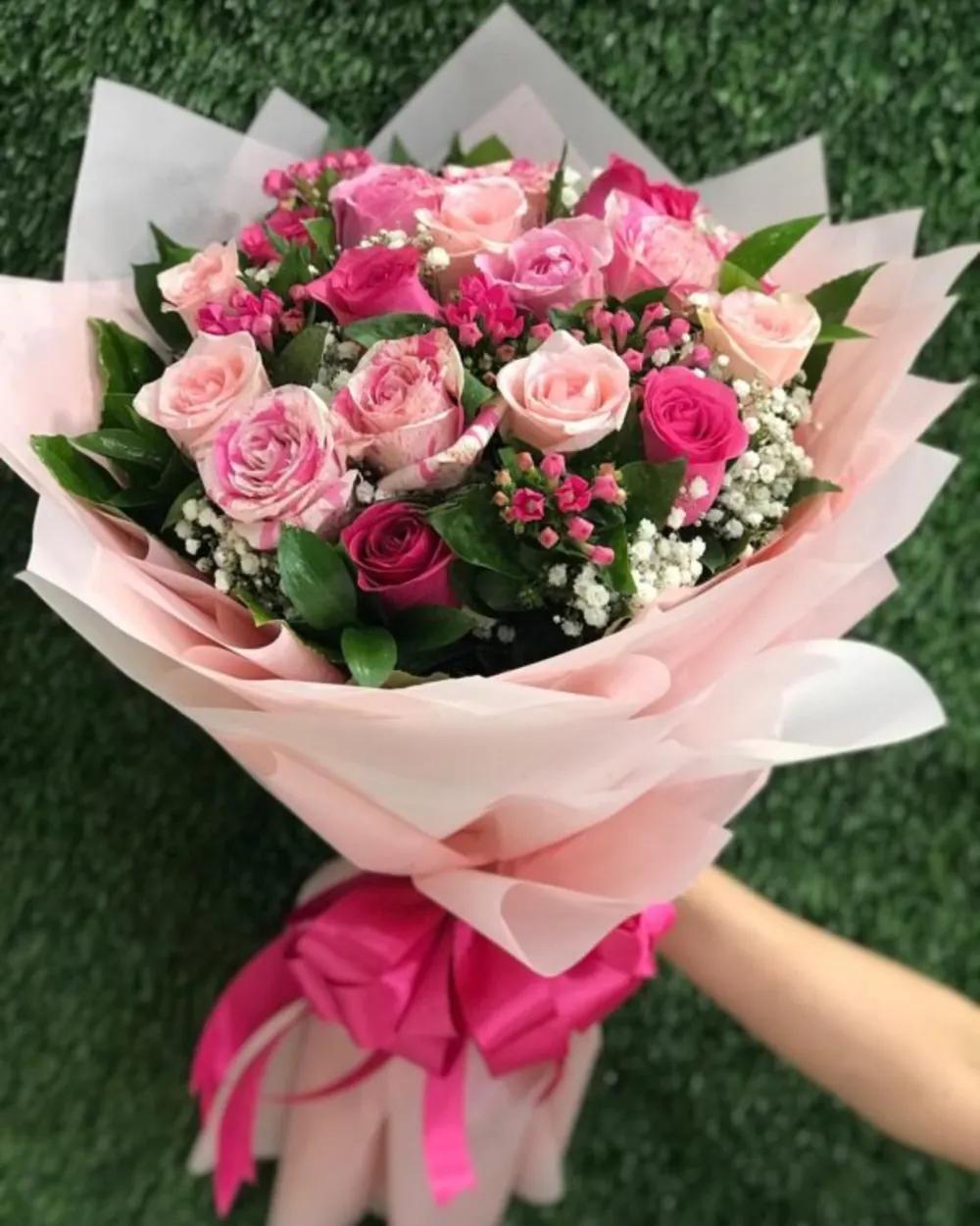 Pink roses bouquet with bouvardia flowers wrapped in pink paper Nundefined