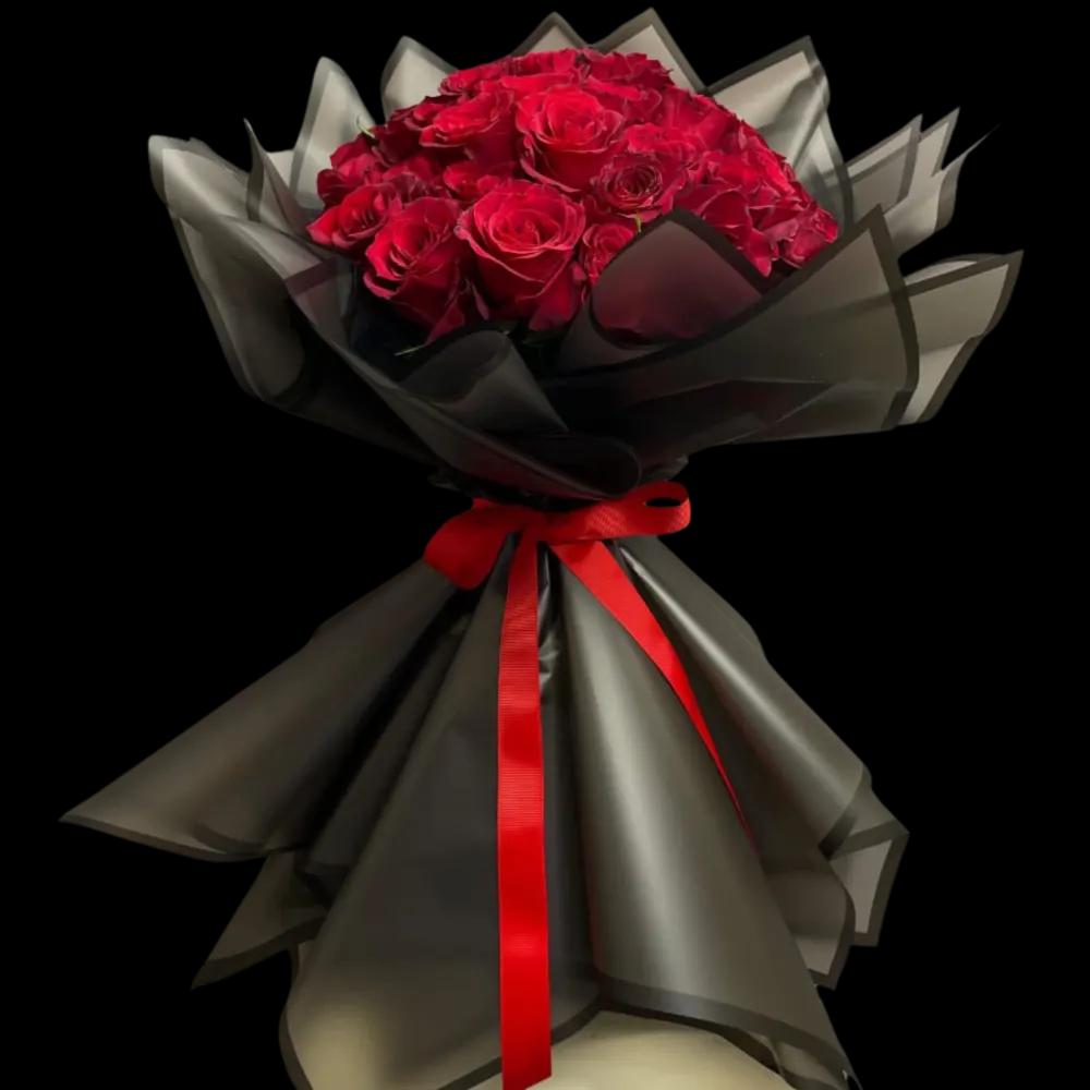 A bouquet of red roses with a black wrapper