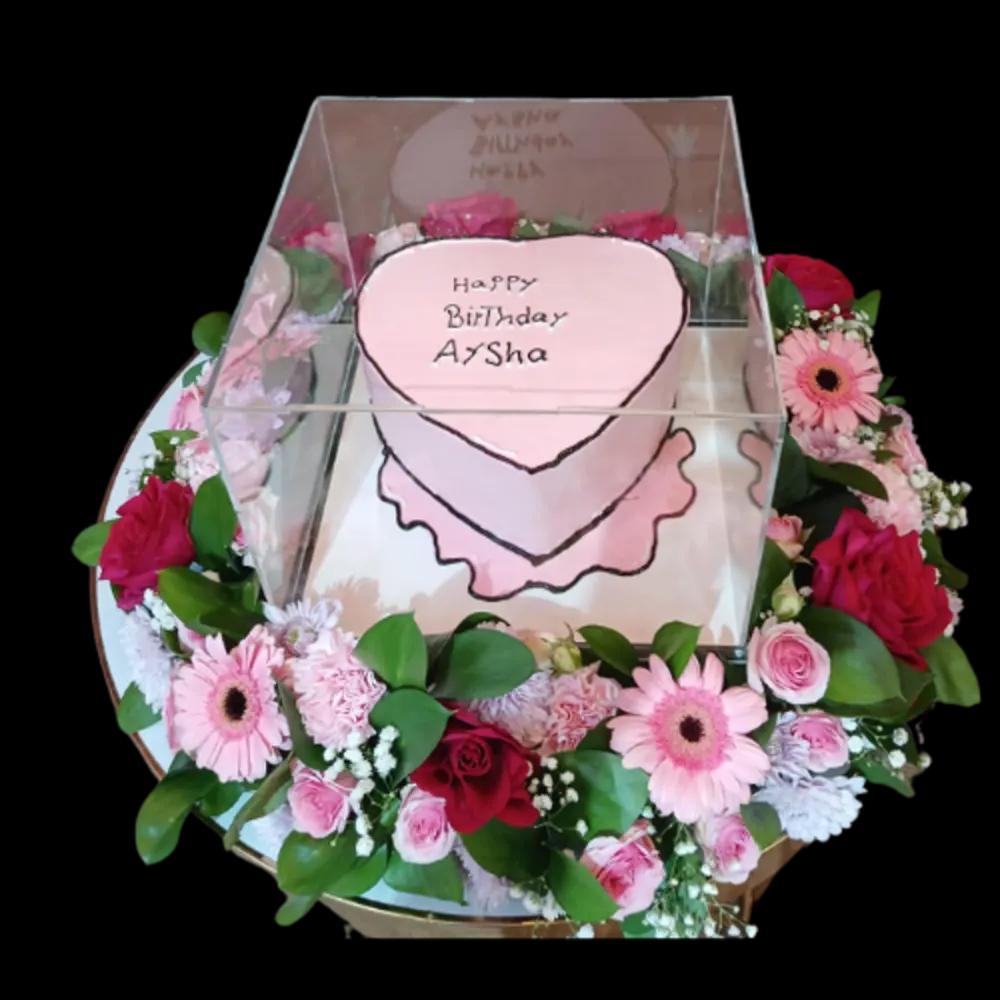A tray of colorful roses with a pink cake