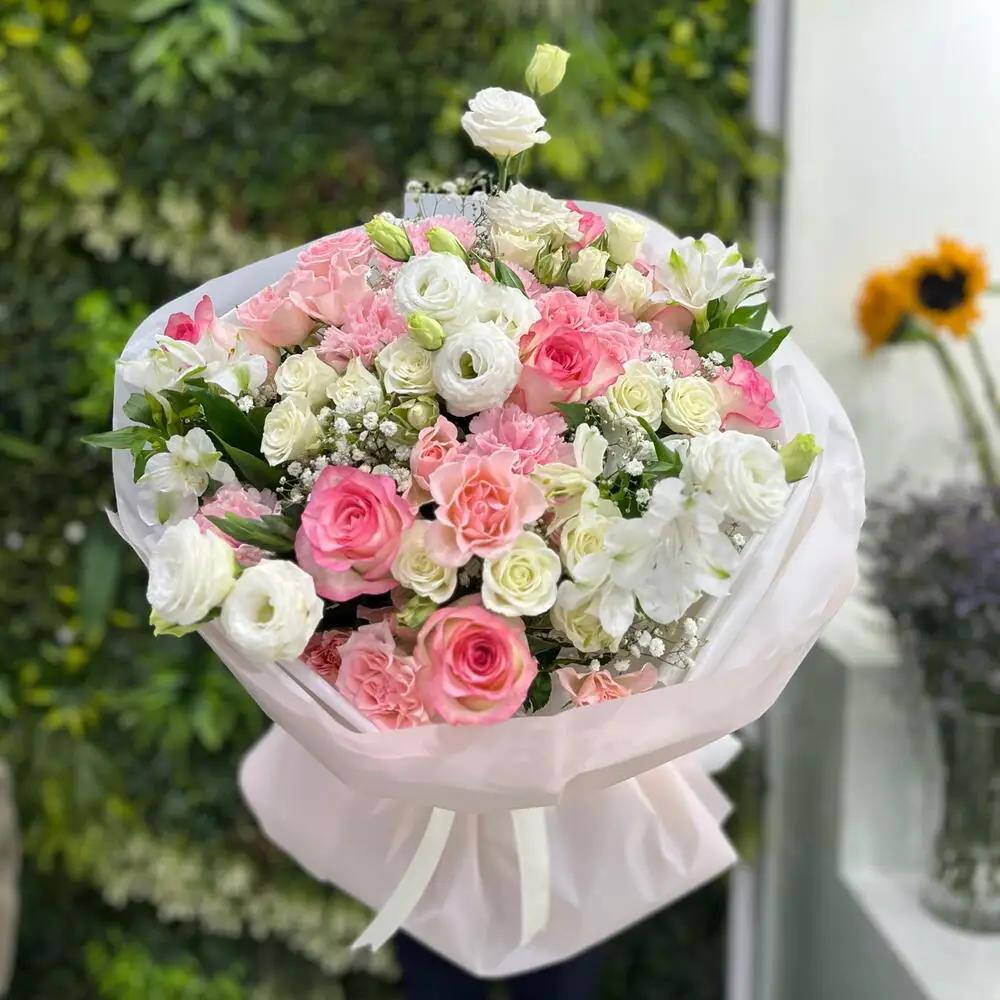 A pink rose bouquet with a purple wrapperFresh pink roses
